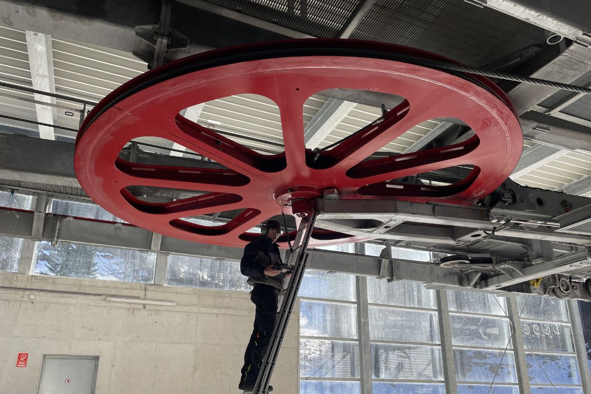 Techniker bei der Wartung einer Seilbahnumlenkscheibe – Condition Monitoring in der Seilbahntechnik